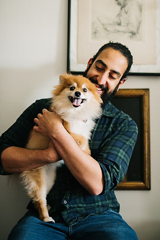 A happy Koala customer holding their pet dog after seeing how easy pet medication can be
